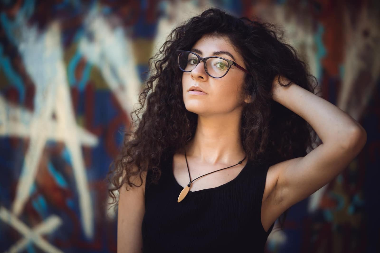 Femme aux cheveux bouclés appliquant un bain d'huile sur ses longueurs
