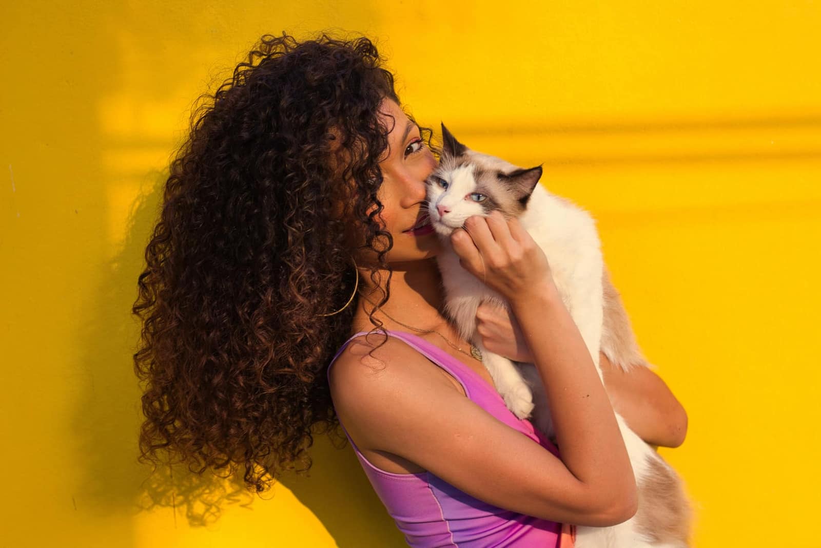 Femme aux cheveux bouclés après une coupe curly cut en salon spécialisé